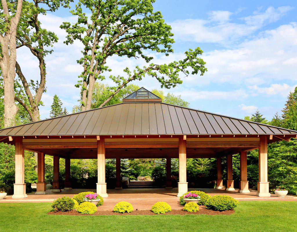 Large outdoor pavilion with stone columns and a standing seam metal roof