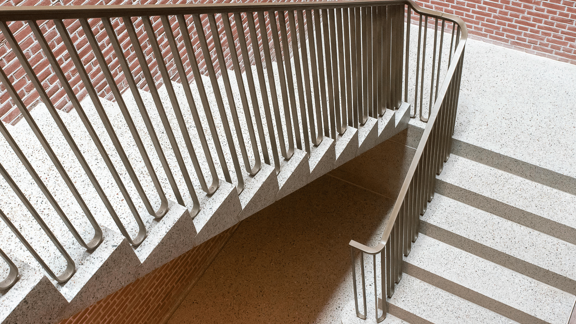 Metal handrail along a brick staircase