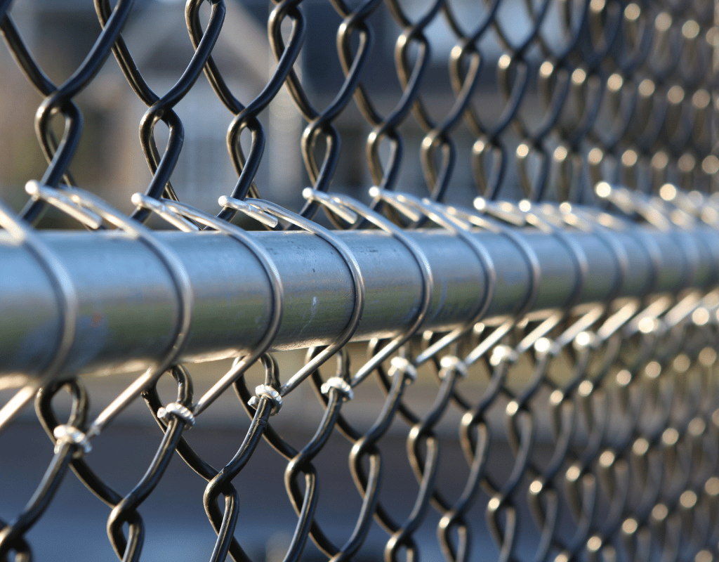 Extreme close-up of galvanized chain link fence mesh and top rail